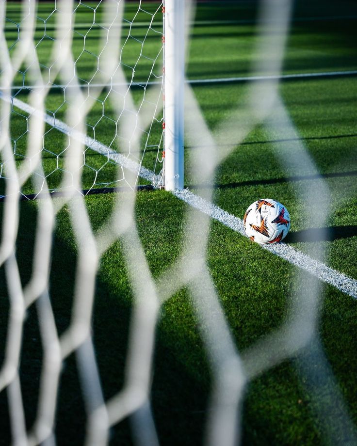 Balón de fútbol junto a la portería