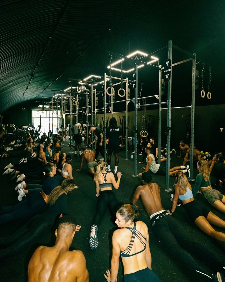 Comunidad entrenando en un box con anillas y estructuras de CrossFit
